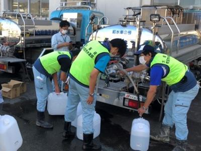 写真：給水車から職員が給水する様子