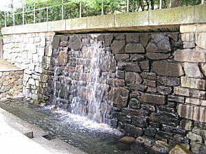 石積みの壁から滝のように地下水を流しています。