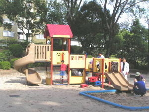 赤や黄色の総合遊具で子供たちが遊んでいます。