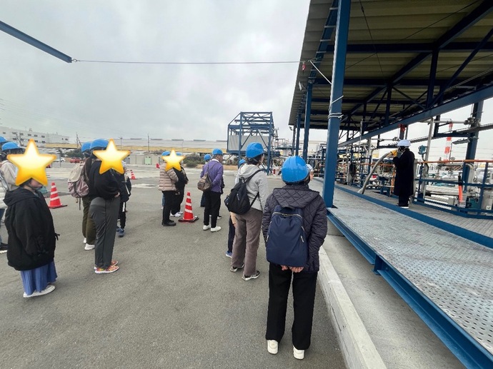 工場で機器の説明を受けている写真