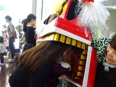 写真：獅子舞の獅子に噛まれる親子